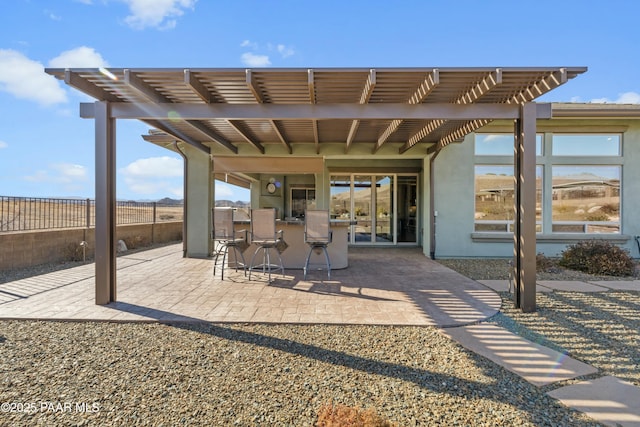 view of patio featuring exterior bar and a pergola