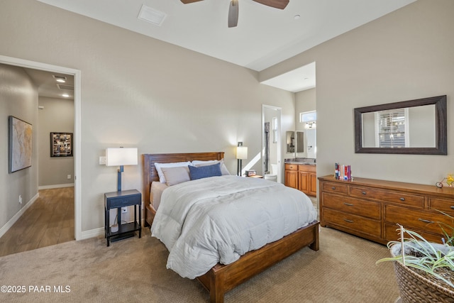 carpeted bedroom with ceiling fan and connected bathroom