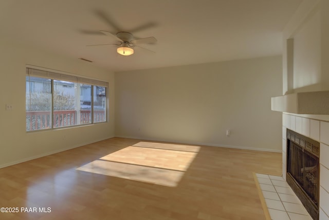 3160 Cascades Dr Unit 16H, Prescott, AZ 86301 - unfurnished living room with light wood-style floors, a tile fireplace, and a ceiling fan