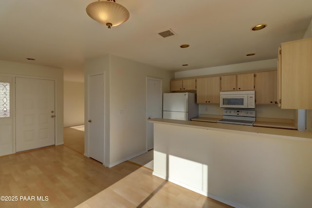 3160 Cascades Dr Unit 16H, Prescott, AZ 86301 - kitchen featuring white appliances, light brown cabinets, recessed lighting, light wood-style flooring, and a peninsula