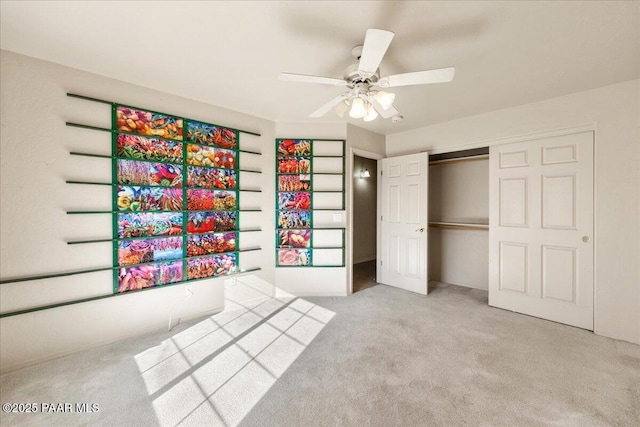 unfurnished bedroom with ceiling fan, light colored carpet, and a closet