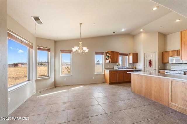 kitchen featuring pendant lighting, white appliances, lofted ceiling, an inviting chandelier, and light tile patterned flooring