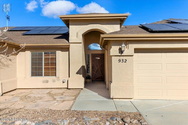 view of exterior entry featuring a garage and solar panels