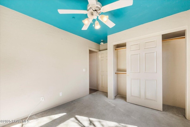 unfurnished bedroom featuring ceiling fan, light colored carpet, and a closet