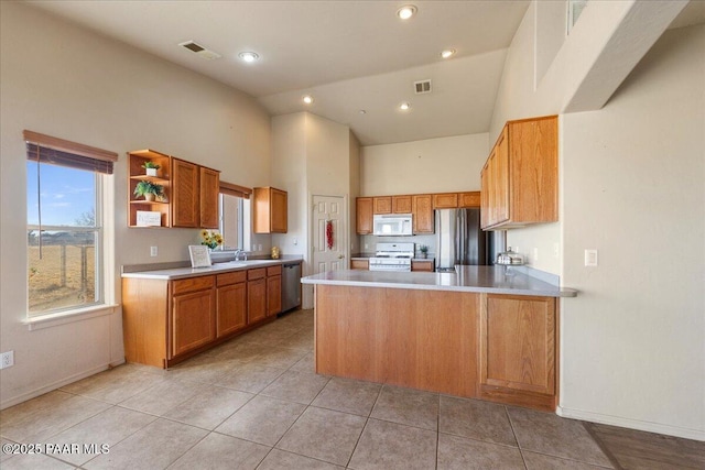 kitchen with light tile patterned floors, kitchen peninsula, stainless steel appliances, high vaulted ceiling, and sink