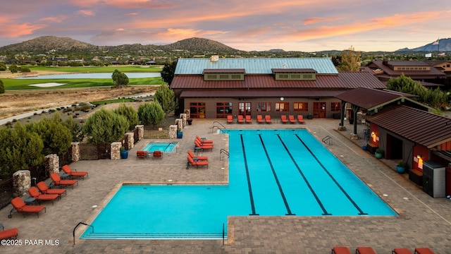 pool featuring a patio area, a mountain view, and a hot tub