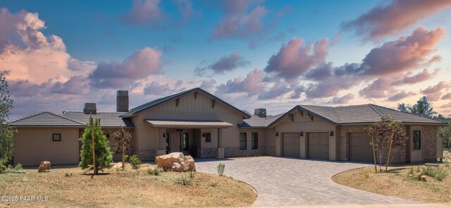 12355 Cooper Morgan Trl, Prescott, AZ 86305 - view of front of property featuring a garage, decorative driveway, a chimney, and stone siding