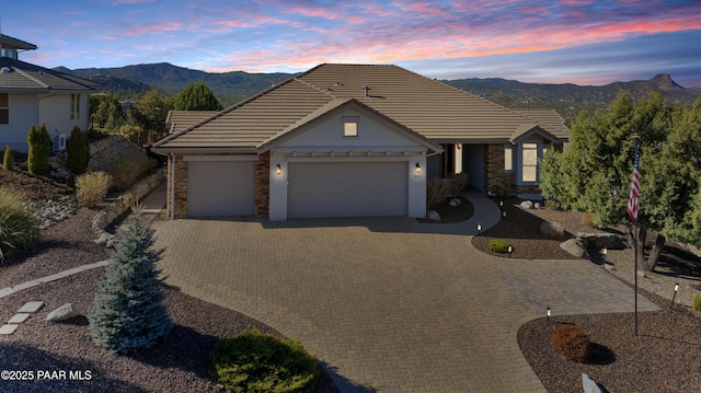 904 Daybreak Dr, Prescott, AZ 86303 - view of front of house with a mountain view, stone siding, a garage, decorative driveway, and a tile roof