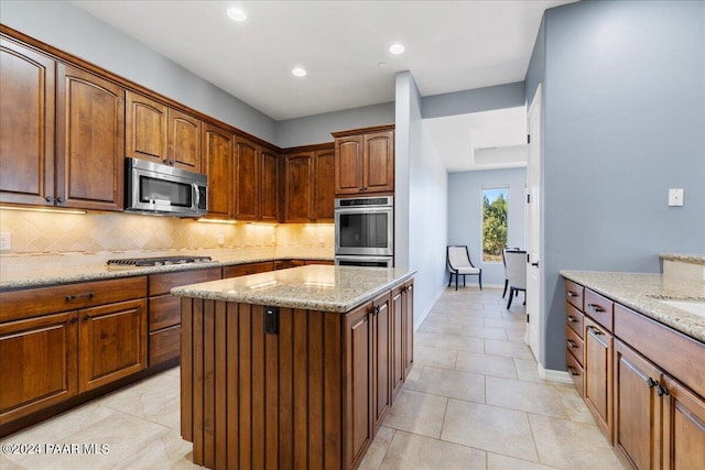 904 Daybreak Dr, Prescott, AZ 86303 - kitchen with stainless steel appliances, tasteful backsplash, light stone counters, a center island, and baseboards