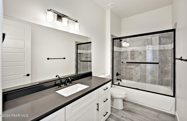 12265 N Petra Cir, Prescott, AZ 86305 - full bathroom with visible vents, toilet, enclosed tub / shower combo, vanity, and wood finished floors