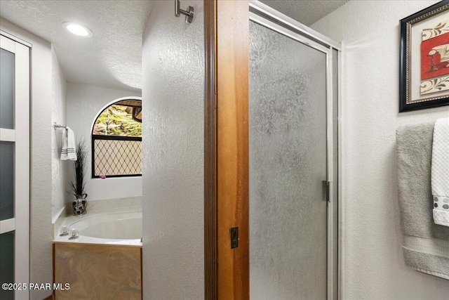 bathroom with a textured ceiling, a textured wall, recessed lighting, a shower stall, and a bath