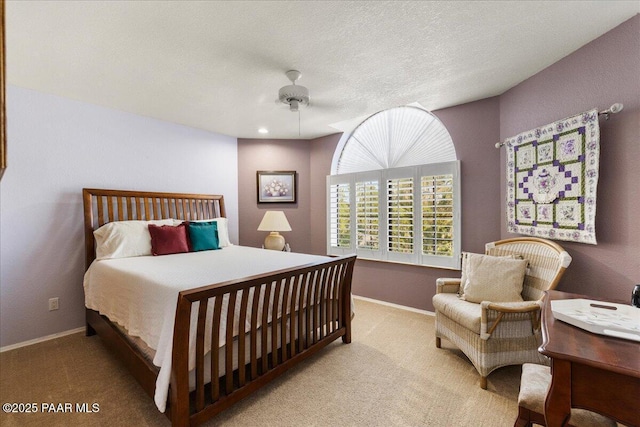 carpeted bedroom with ceiling fan, baseboards, and a textured ceiling