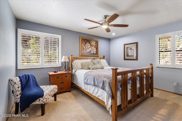 carpeted bedroom featuring a ceiling fan, multiple windows, a textured ceiling, and baseboards