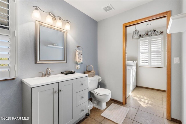 bathroom with visible vents, toilet, vanity, tile patterned flooring, and baseboards