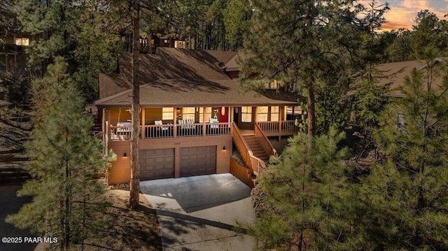 rustic home featuring a garage, driveway, and stairway