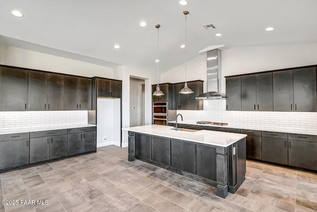 kitchen with visible vents, lofted ceiling, wall chimney exhaust hood, light countertops, and a sink