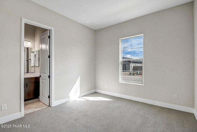 unfurnished bedroom with light colored carpet and ensuite bathroom