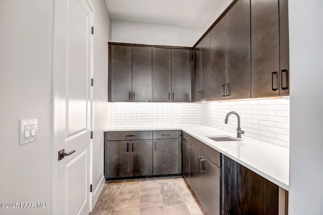 kitchen with sink, dark brown cabinets, and backsplash