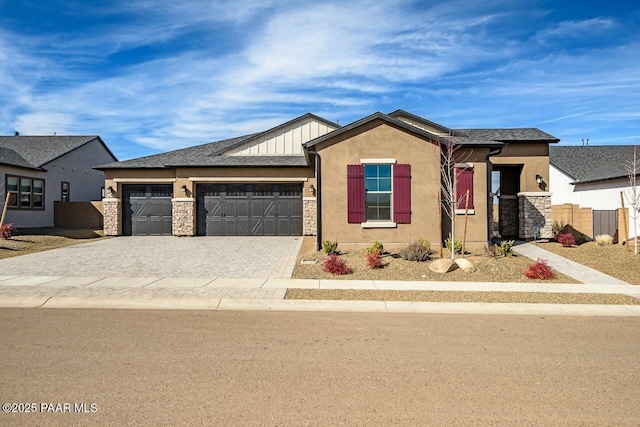 view of front of property with decorative driveway, stucco siding, board and batten siding, a garage, and stone siding