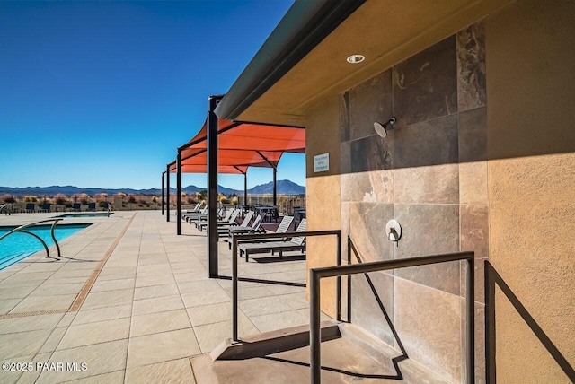 view of swimming pool with a mountain view and a patio area