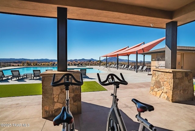 view of patio featuring a community pool, a gazebo, a water and mountain view, and exterior bar