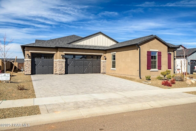 view of front of house featuring an attached garage, stone siding, decorative driveway, roof with shingles, and stucco siding