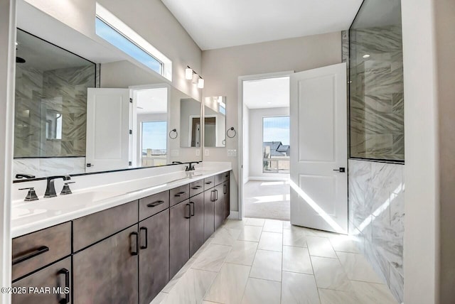 bathroom with tiled shower and vanity