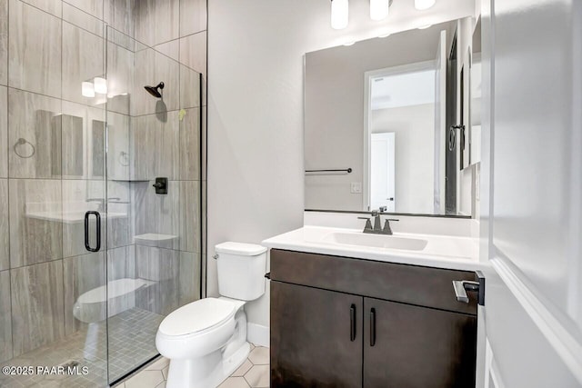 bathroom featuring vanity, toilet, tile patterned flooring, and a shower with door