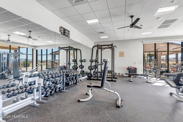 workout area with ceiling fan and a paneled ceiling