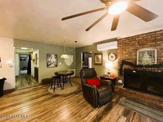 1696 W Linger Ln, Prescott, AZ 86303 - living area with an AC wall unit, wood finished floors, a fireplace, and ceiling fan