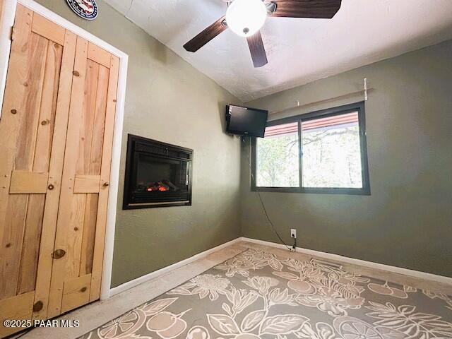1696 W Linger Ln, Prescott, AZ 86303 - empty room featuring a glass covered fireplace, light carpet, and ceiling fan