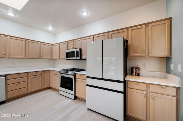 kitchen with light brown cabinetry, stainless steel appliances, and light hardwood / wood-style floors