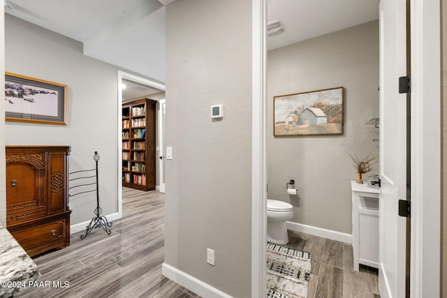 bathroom with wood-type flooring and toilet