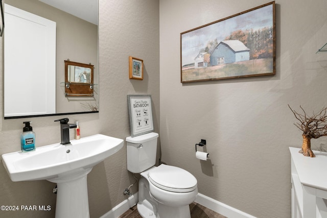 bathroom featuring sink, hardwood / wood-style floors, and toilet