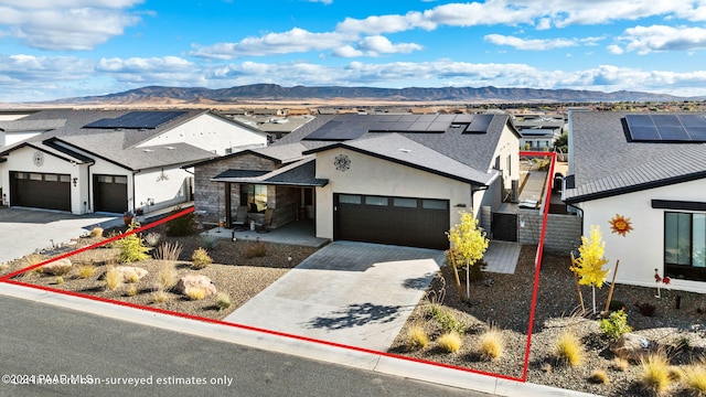 view of front of home featuring a mountain view, a garage, and solar panels