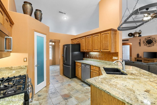 7785 E Bramble Berry Ln, Prescott Valley, AZ 86315 - kitchen featuring appliances with stainless steel finishes, a sink, a high ceiling, light stone counters, and arched walkways