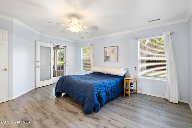bedroom with wood finished floors, access to outside, multiple windows, ornamental molding, and baseboards