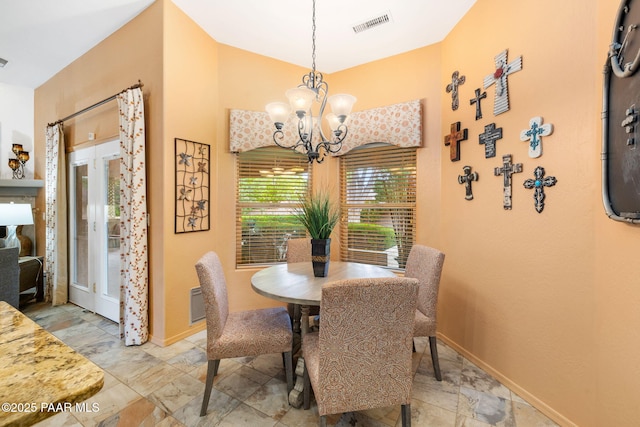 dining area featuring a chandelier and baseboards