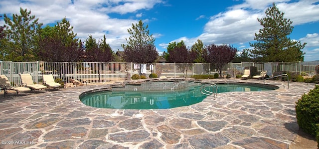 view of pool featuring fence, a patio, and a pool with connected hot tub