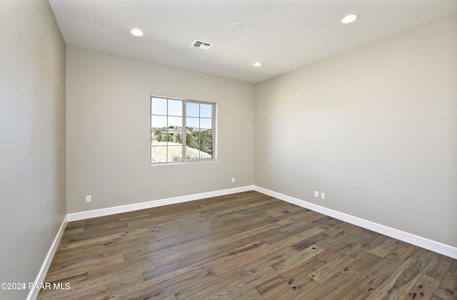 empty room featuring baseboards, visible vents, recessed lighting, and dark wood-style flooring