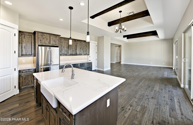 kitchen with high end refrigerator, a sink, a notable chandelier, dark wood-style floors, and recessed lighting