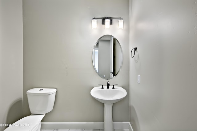 half bathroom with toilet and baseboards
