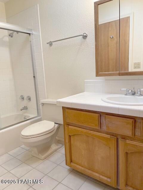 full bathroom with vanity, shower / bath combination with glass door, tile patterned floors, toilet, and tasteful backsplash