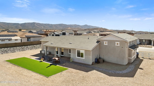rear view of house with a residential view, a patio area, a fenced backyard, and a mountain view