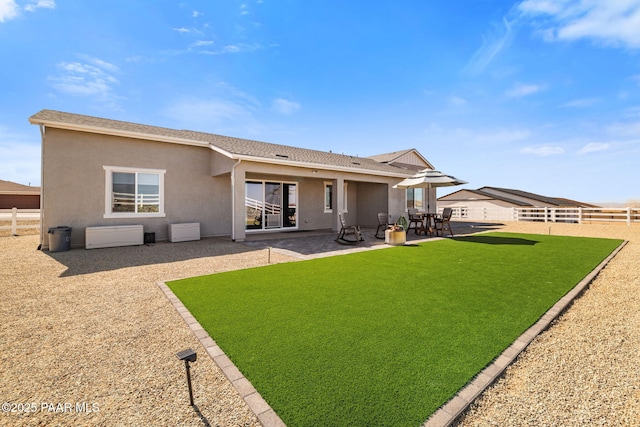 back of property with a patio, a lawn, a fenced backyard, and stucco siding