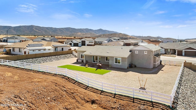 rear view of house featuring a residential view, a patio area, a fenced backyard, and a mountain view