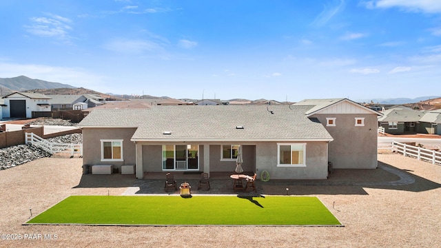 back of property featuring a patio, a fenced backyard, a yard, a residential view, and stucco siding