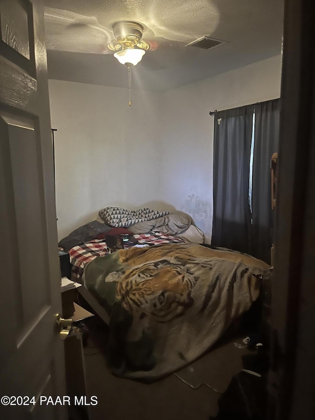 bedroom featuring a textured ceiling and ceiling fan