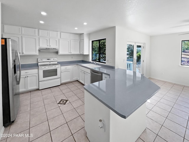 kitchen featuring sink, kitchen peninsula, light tile patterned floors, white cabinetry, and stainless steel appliances