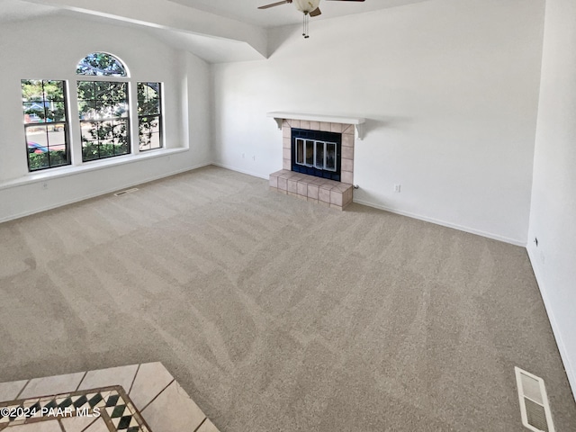 unfurnished living room with ceiling fan, carpet floors, a tile fireplace, and lofted ceiling